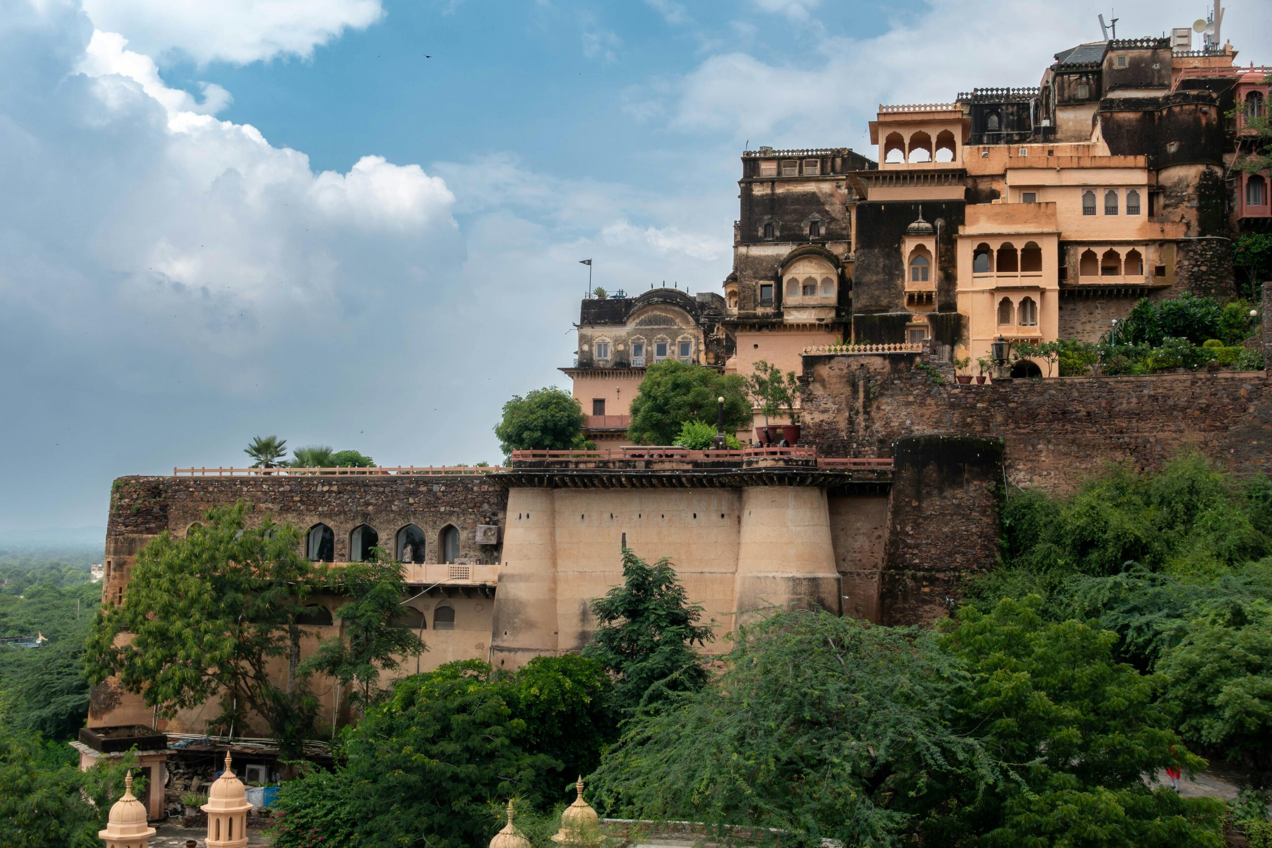 Explore the historic Neemrana Fort in Rajasthan, showcasing intricate architecture against a beautiful sky.